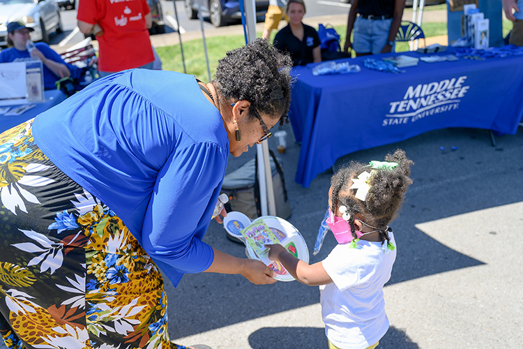 MTSU College of Liberal Arts Dean Leah Lyons chats with a young visitor to MTSU’s information tables at the 2022 Juneteenth Festival in Murfreesboro, Tenn. Middle Tennessee State University will again have representatives staffing the 2023 street festival Saturday, June 17. (MTSU file photo by James Cessna)