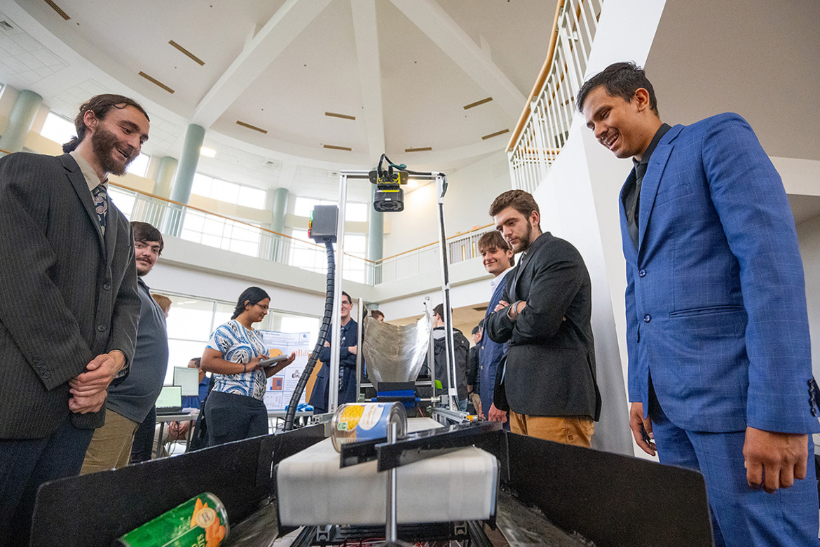Middle Tennessee State University Mechatronics Engineering students admire the capability of the robot created to open cans containing fruit and vegetables Saturday, May 3, during the Department of Engineering Technology Mech-Tech held in the Miller Education Center second-floor atrium on Bell Street in Murfreesboro, Tenn. (MTSU photo by Cat Curtis Murphy)