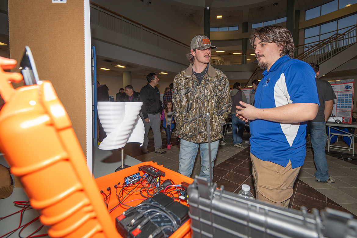 First-place Middle Tennessee State University Engineering Technology Mech-Tech Engineering division winner Hunter McMath, right, explains his senior capstone project to a fellow student during the annual fall Mech-Tech event held Dec. 5 in the Miller Education Center on Bell Street in Murfreesboro, Tenn. (MTSU photo by Cat Curtis Murphy)