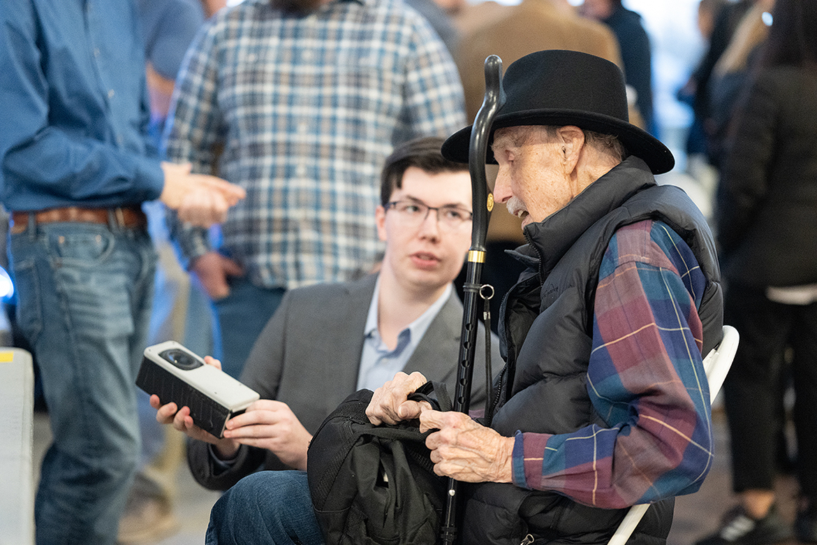 Brian Johnson, left, of Murfreesboro, a senior Middle Tennessee State University Department of Engineering Technology mechatronics engineering major, explains to his grandfather, Forrest Caldwell, 96, of Houston, Texas, the inner workings of the Synapse Portable Network Speaker System capstone project his five-member team created as part of the biannual Mech-Tech end of semester wrap-up event in the Miller Education Center on Bell Street in Murfreesboro, Tenn. (MTSU photo by Cat Curtis Murphy)