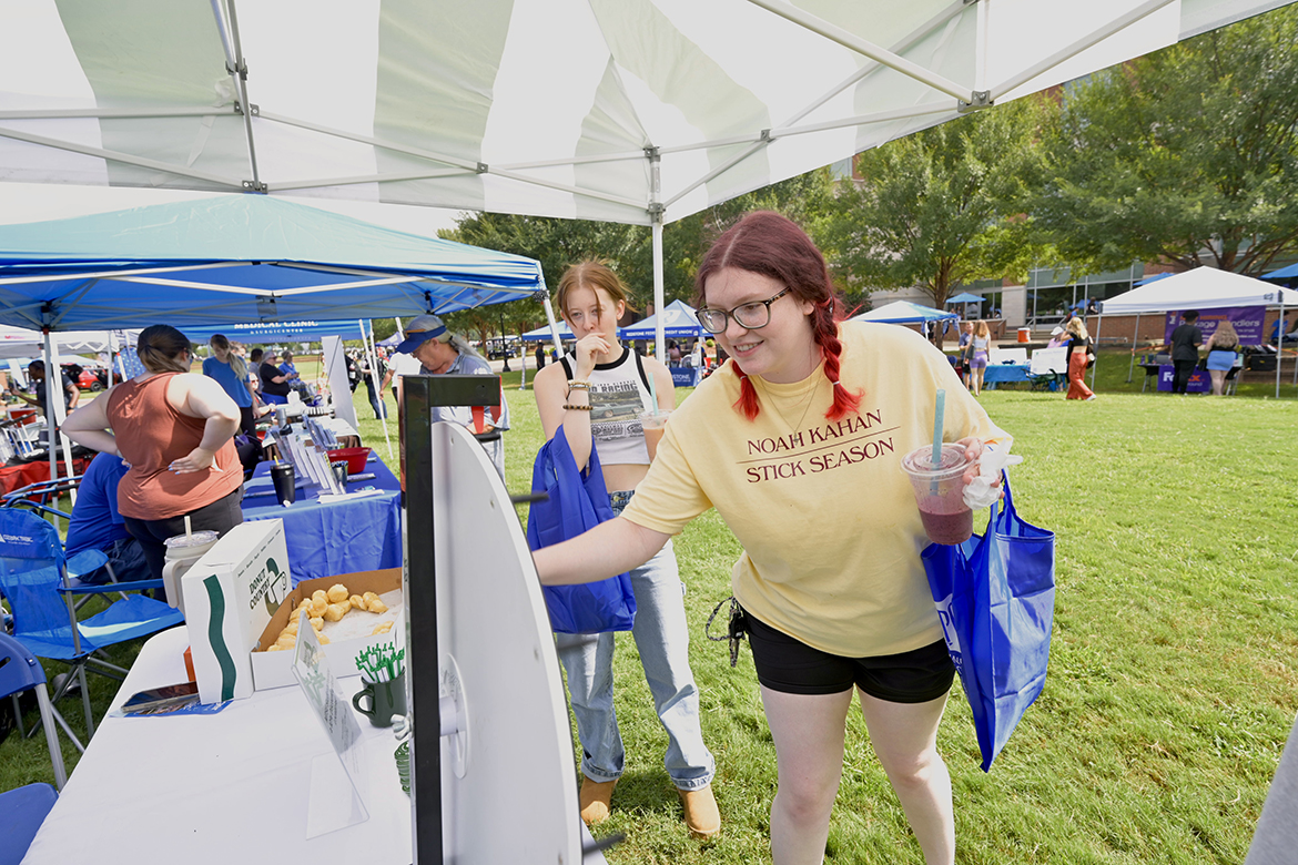 a junior double major in photography and theatre from Manchester, Tennessee, spins to win a prize, as her friend, Riley Joffs, a sophomore theatre major from Murfreesboro, Tenn., waits her turn. (MTSU photo by Andy Heidt)