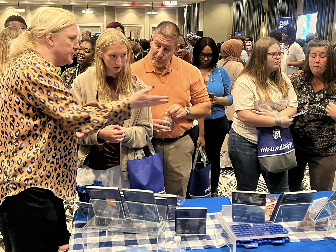 Beverly Keel, left, dean for the Middle Tennessee State University College of Media and Entertainment, shows a prospective high school student and her father the array of programs and departments available. Their conversation took place recently during the MTSU True Blue Tour event at Esplande Memphis in Cordova, Tenn. (MTSU photo by Andrew Oppmann)