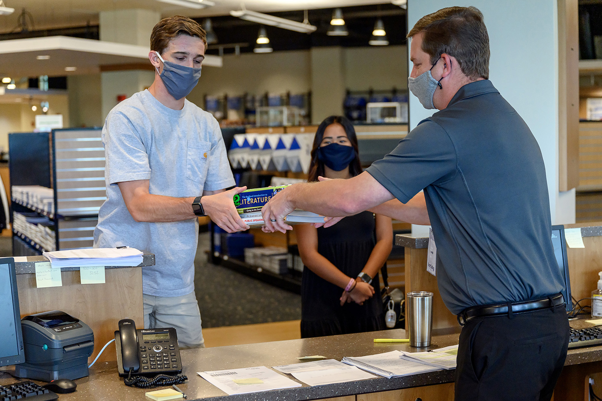 MTSU students Luke Vinson, left, and Krystal Panyavong return books to MTSU Phillips Bookstore textbook manager David Phillips Tuesday, June 16, during the first day of the bookstore reopening in the Student Union Building. Phillips Bookstore is now operated by Barnes and Noble College. (MTSU photo by J. Intintoli)