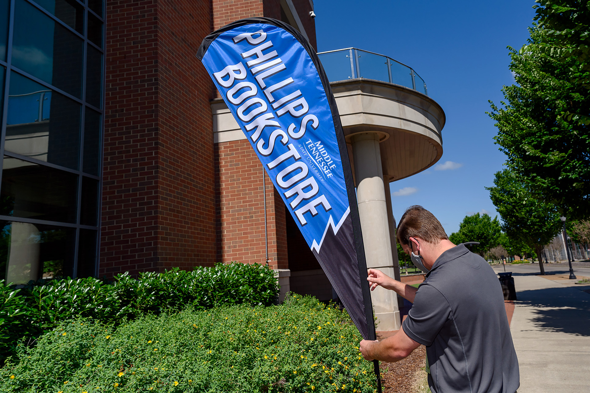 Phillips Bookstore in the MTSU Student Union will be open from 10 a.m. to 6 p.m. Saturday, Sept. 4. David Phillips, textbook manager at the bookstore that is operated by Barnes & Noble College, adjusts the sign directing foot traffic at the Student Union Building's exterior entrance facing MTSU Boulevard. (MTSU file photo by J. Intintoli)