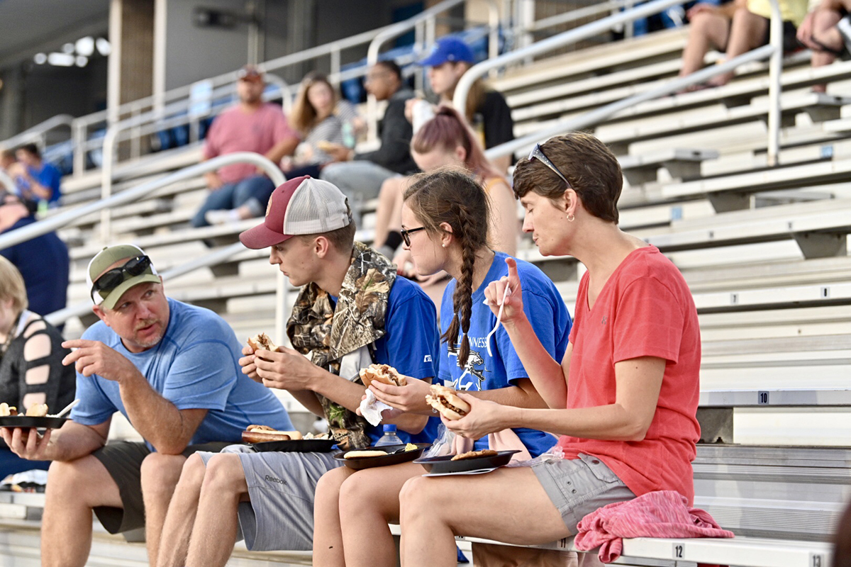 A family enjoys sitting in the Floyd Stadium stands eating food provided for the President’s Picnic following University Convocation in Murphy Center Saturday, Aug. 24. (MTSU photo)
