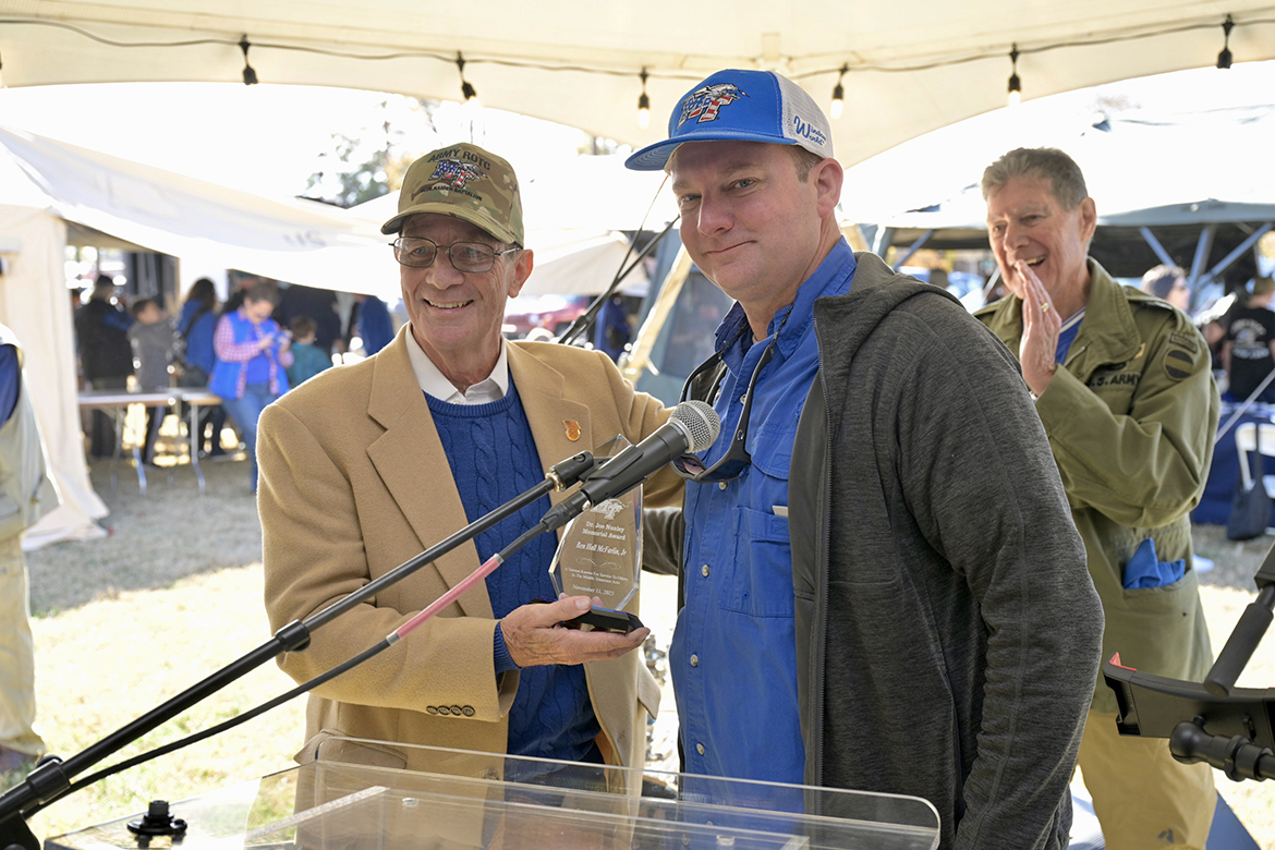 Retired Judge Ben Hall McFarlin, left, of Murfreesboro, Tenn., accepts the 2023 Joe Nunley Award from Trey Nunley Saturday, Nov. 11, on the west side of the Middle Tennessee State University campus between the MTSU Military Memorial site and Rutledge Hall. Alumnus and veteran Bud Morris of Murfreesboro cheers the selection in the background. (MTSU photo by Andy Heidt)