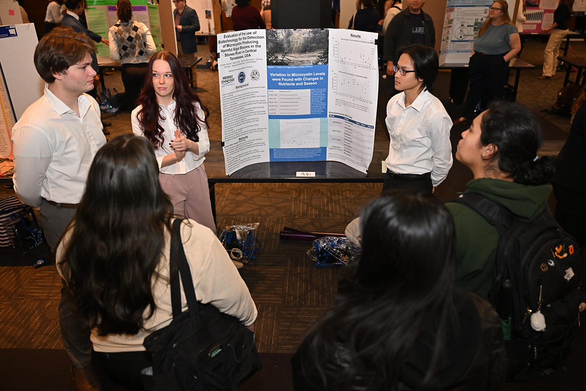 Middle Tennessee State University biology major Andrew Hetrick, left, biochemistry major Sabrina McKenna and chemistry major Muny Chet discuss their team’s biotechnology research from the Stones River in Middle Tennessee during the universitywide Scholars Day finale Friday, March 21, in the Student Union Ballroom on campus in Murfreesboro, Tenn. Their team also included Zahraa Alrubye and Jessica Landaverde. (MTSU photo by James Cessna)