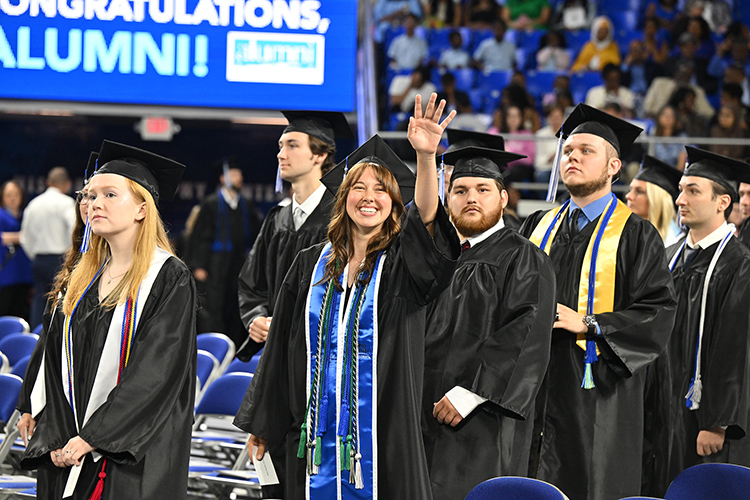 A proud Middle Tennessee State University graduate waves to a supporter at the spring 2025 morning commencement ceremony held Saturday, May 10, inside Murphy Center on the MTSU campus in Murfreesboro, Tenn. More than 2,375 graduates received their degrees during three ceremonies over two days. (MTSU photo by James Cessna)
