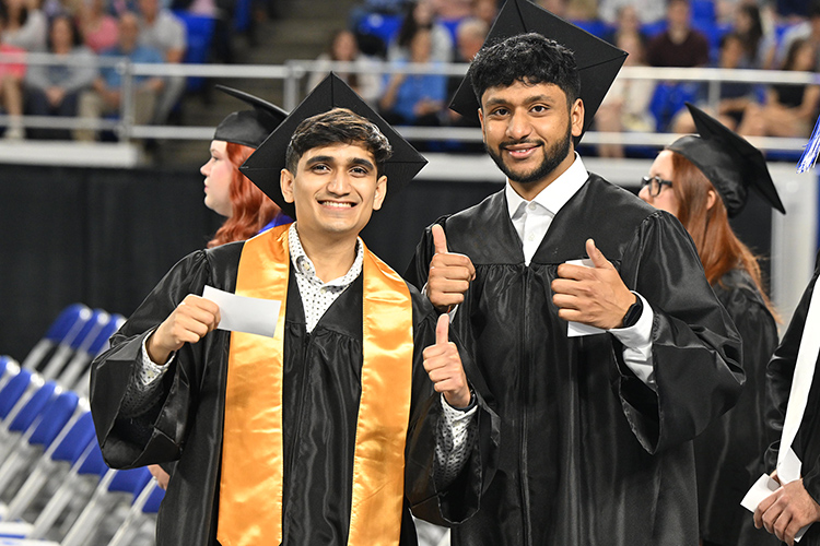 Two proud graduates of Middle Tennessee State University give a thumbs up as they prepare to receive their hard-earned degrees during the spring 2025 morning commencement ceremony held Saturday, May 10, inside Murphy Center on the MTSU campus in Murfreesboro, Tenn. (MTSU photo by James Cessna)