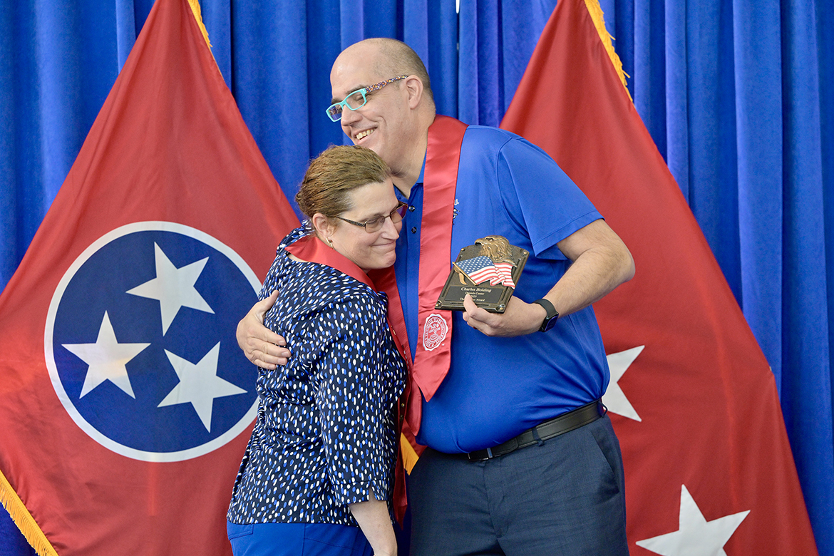 Journey Award recipient Chuck Bolding, right, of McMinnville, Tenn., a Middle Tennessee State University graduating senior veteran, receives a hug from an admirer during the 30th Graduating Veterans Stole Ceremony Thursday, May 8, at the Miller Education Center on Bell Street in Murfreesboro, Tenn. (MTSU photo by Andy Heidt)