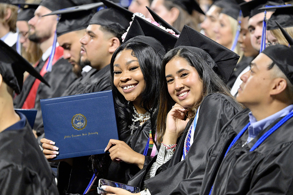 A proud Middle Tennessee State University graduate smiles with a classmate while holding up her degree during the summer 2025 commencement ceremony held Saturday, Aug. 9, inside Murphy Center on campus in Murfreesboro, Tenn. A total of 722 graduates received their degrees to close out the university’s 2024-25 academic year. (MTSU photo by Andy Heidt)