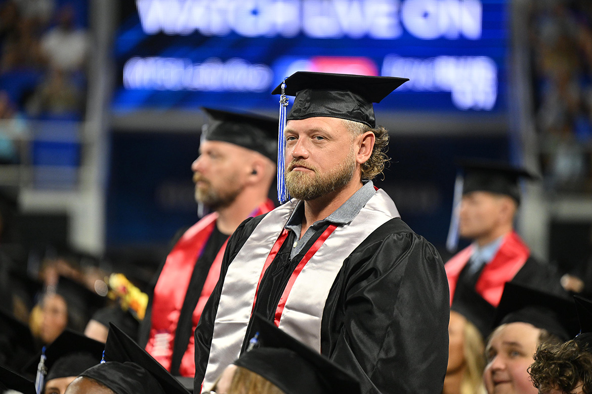 Wearing their special red stoles, graduating Middle Tennessee State University student veterans stand as they receive special acknowledgment during the summer 2025 commencement ceremony held Saturday, Aug. 9, inside Murphy Center on campus in Murfreesboro, Tenn. (MTSU photo by James Cessna)