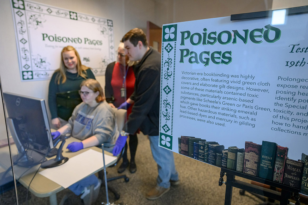 Chemistry instructor Sarah Pierce, standing at left, Special Collections librarian Susan Martin, center, and chemistry graduate student Ethan Coyle look over the shoulders of forensic science student Brittney Cupp as they examine incoming data from the X-ray fluorescence spectroscopy, or XRF, set up in the Special Collections at Middle Tennessee State University’s James E. Walker Library in Murfreesboro, Tenn. The machine is used to identify and quantify toxic compounds and heavy metals found in the pigments used in many 19th-century books housed in the university’s Special Collections. The “Poisoned Pages” project was made possible through a University Research and Creative Activity, or URECA, grant that bolstered the collaboration between the Department of Chemistry and the library. (MTSU photo by J. Intintoli)