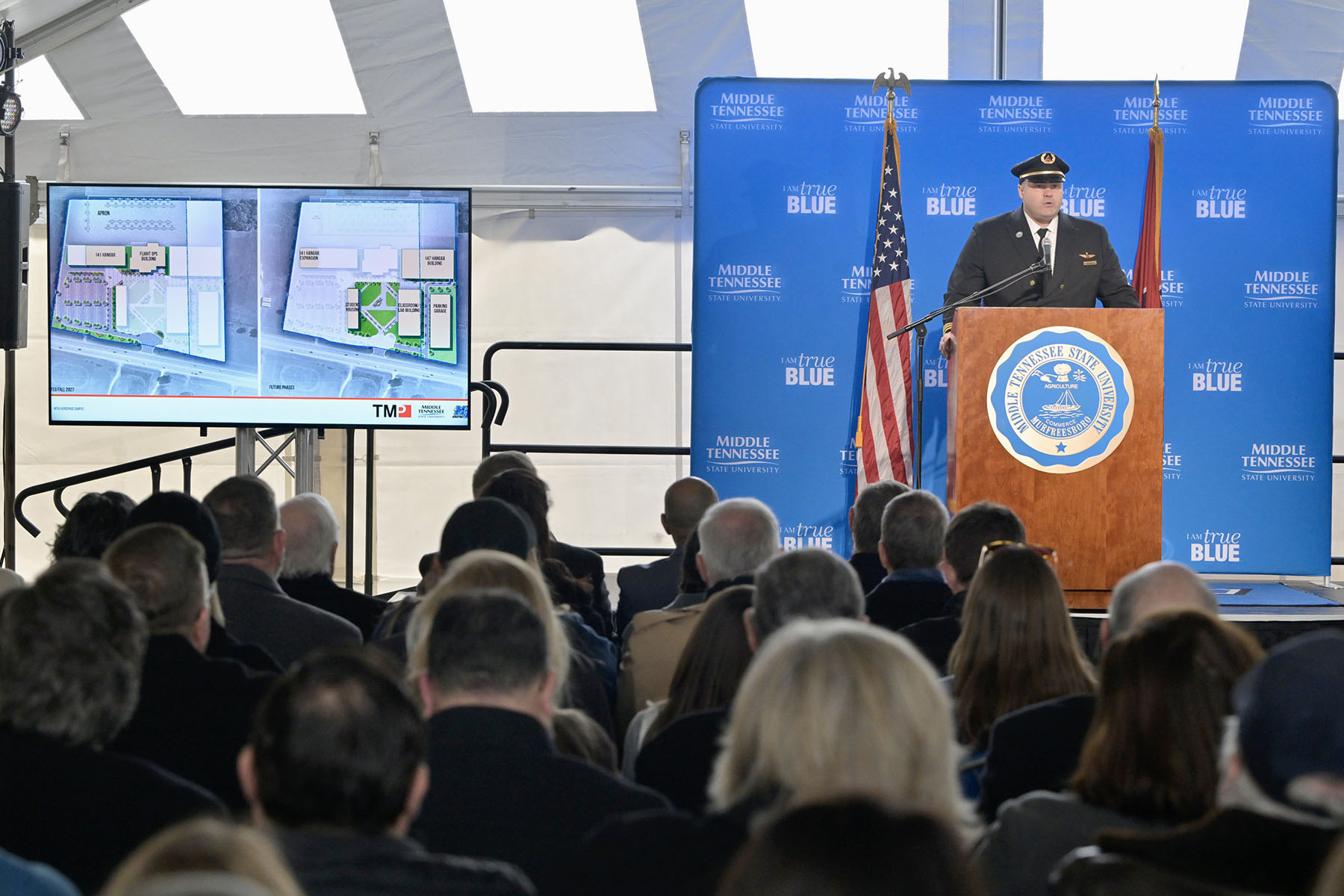 Middle Tennessee State University alumnus and Delta Airlines pilot Eric Wesley talks about the Delta Propel program partnership with MTSU during the groundbreaking ceremony for the new $73.4 million MTSU Aerospace facility being built at the Shelbyville Municipal Airport in Shelbyville, Tenn. Seen on a screen next to Wesley on stage is a rendering of the future facility that will serve as home to the university’s flight operations. (MTSU photo by Andy Heidt)