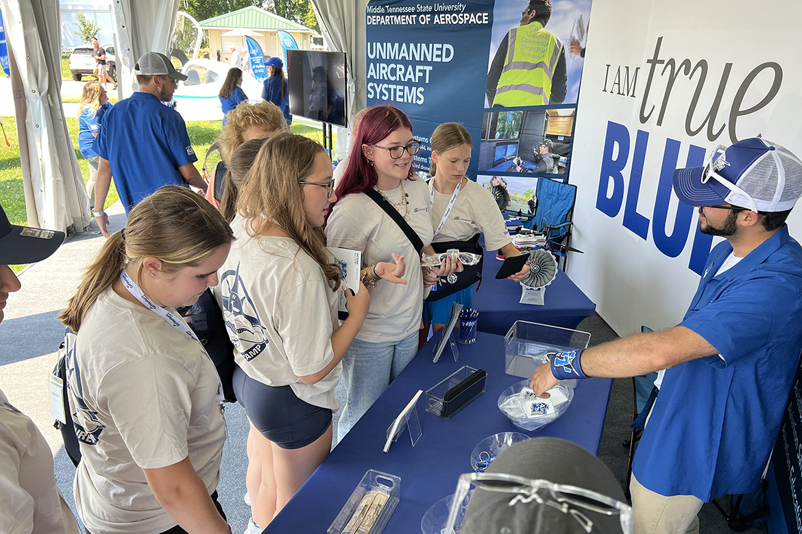 Visitors stop by the Middle Tennessee State University Aerospace Department’s exhibition booth set up at the 72nd EAA AirVenture aviation showcase held July 21-27 in Oshkosh, Wis. MTSU sent a delegation of students, faculty and staff to network and tout its flight program at the event, known as “the world’s largest gathering of aviation enthusiasts.” (MTSU photo by Andrew Oppmann)