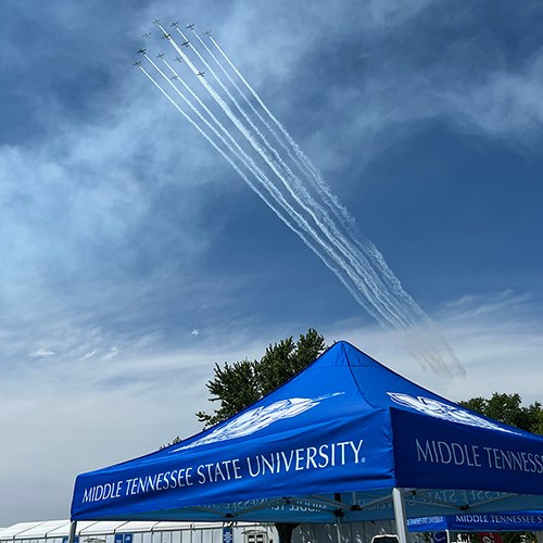 Aircraft participating in the 72nd EAA AirVenture aviation showcase held July 21-27 in Oshkosh, Wisc., fly high above the Middle Tennessee State University tent on location for the weeklong event, known as “the world’s largest gathering of aviation enthusiasts.” (MTSU photo by Andrew Oppmann)