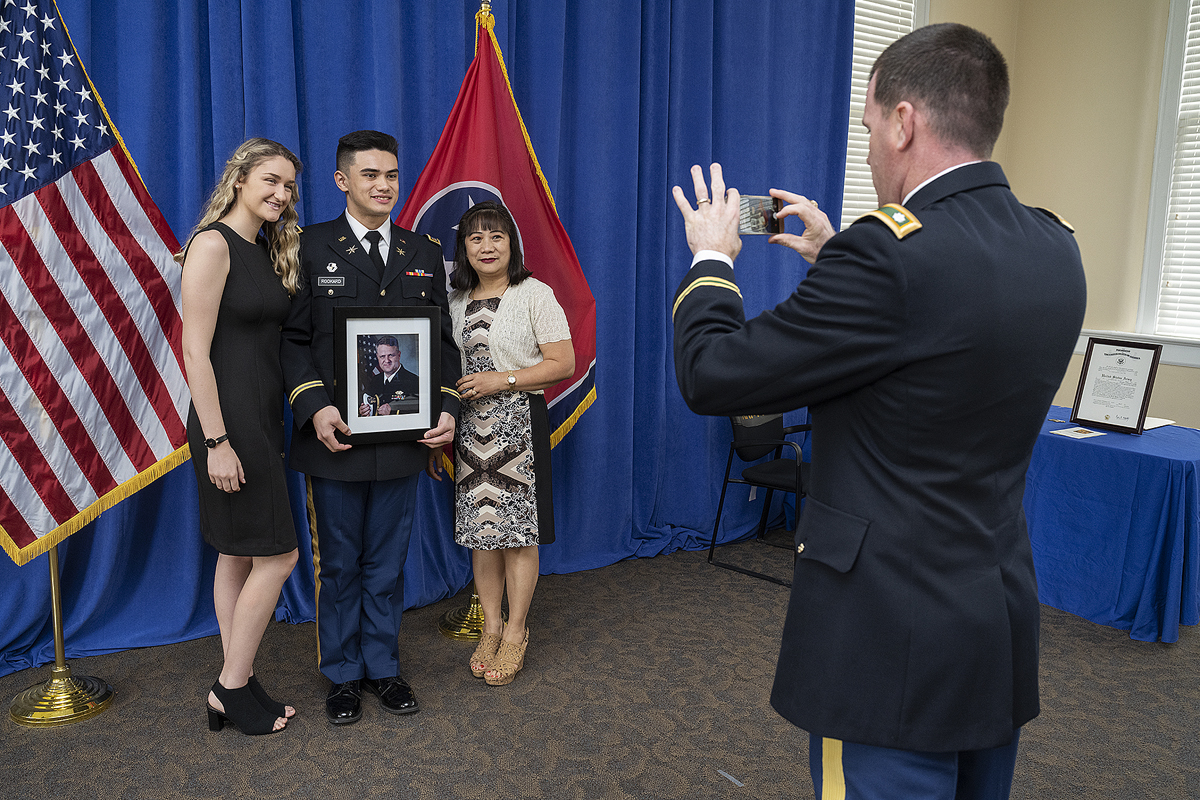 U.S. Army Lt. Col. Carrick McCarthy, right, takes a cell phone photo of newly commissioned 2nd Lt. Curtis Rookard Jr., of Oak Ridge, Tenn., Tuesday, May 12, during the MTSU ROTC commissioning ceremony in the Tom H. Jackson Building’s Cantrell Hall. Rookard holds a photo of his father, Lt. Cmdr. Curtis Rookard Sr. Lily Hendrickson, left, Curtis Rookard Jr.’s girlfriend, and his mother, Marita Rookard, attended the ceremony. (MTSU photo by Andy Heidt)
