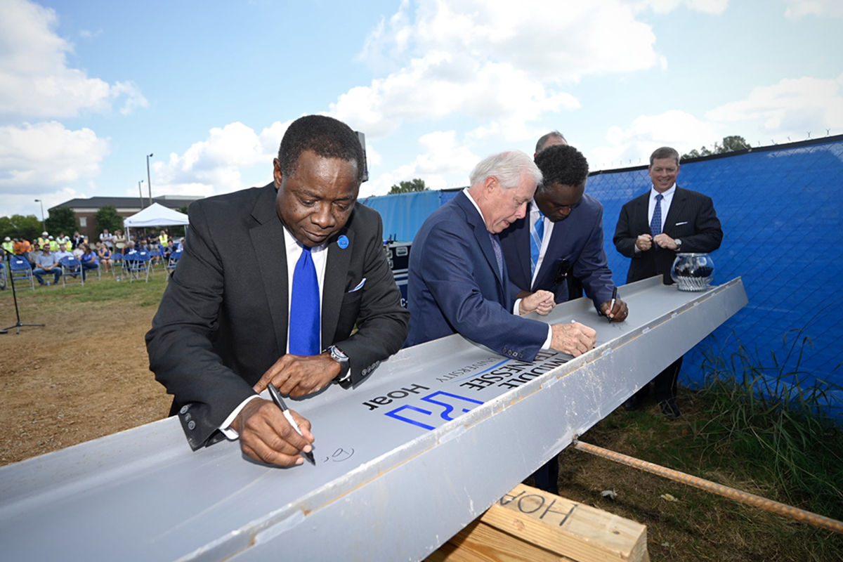 MTSU President Sidney A. McPhee, left, and MTSU Board of Trustees members J.B. Baker, left, Darrell Freeman, Steve Smith and Pete Delay sign the ceremonial final beam to be placed at the top of the School of Concrete and Construction Management building Tuesday, Sept. 14, in the Bragg Parking lot adjacent to the construction site. (MTSU photo by J. Intintoli)