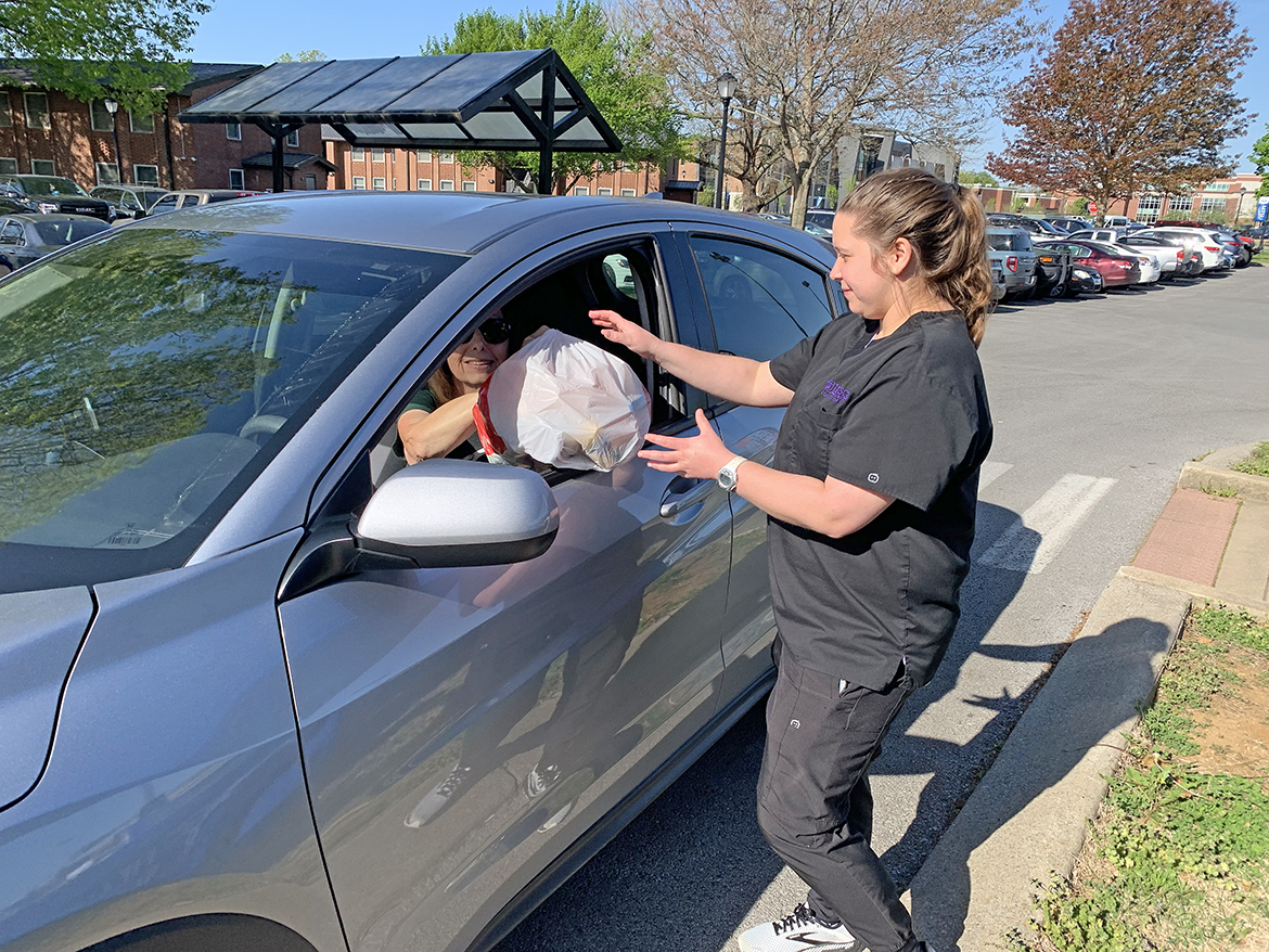 Karen Sluder, left, hands a full plastic grocery bag of expired vitamins and prescriptions to Lindsey McInturff of Nashville, Tennessee, a fourth-year Lipscomb University College of Pharmacy student, Tuesday, April 18, during the spring Middle Tennessee State University Drug Take-Back Day sponsored by Campus Police and Pharmacy and the MTSU Stormwater Project. MTSU officials collected nearly 54 pounds of expired and unused prescription, over-the-counter and pet medications near the Campus Pharmacy drive-thru outside the Health, Wellness and Recreation Center. McInturff is assisting Campus Pharmacy the entire month of April. (MTSU photo by Randy Weiler)