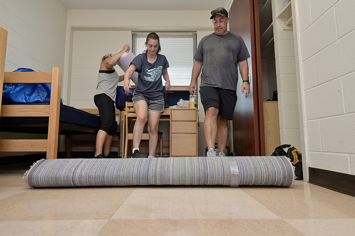 As mom, Sue Durrill, unwraps some bedding material, daughter and MTSU freshman Kendall Durrill and father Jeff Durrill of Baltimore, Md., roll out a new rug for the audio production major’s room in Corlew Hall Friday, Aug. 19, 2022, during a move-in day on campus. University officials say residence halls are already at capacity for Fall 2023. (MTSU file photo by Andy Heidt)