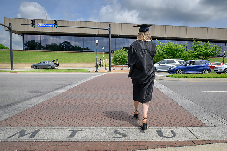 A Middle Tennessee State University graduate crosses Middle Tennessee Boulevard to accept her degree during the spring 2025 commencement ceremony held Friday, May 9, inside Murphy Center on the MTSU campus in Murfreesboro, Tenn. (MTSU photo by J. Intintoli)