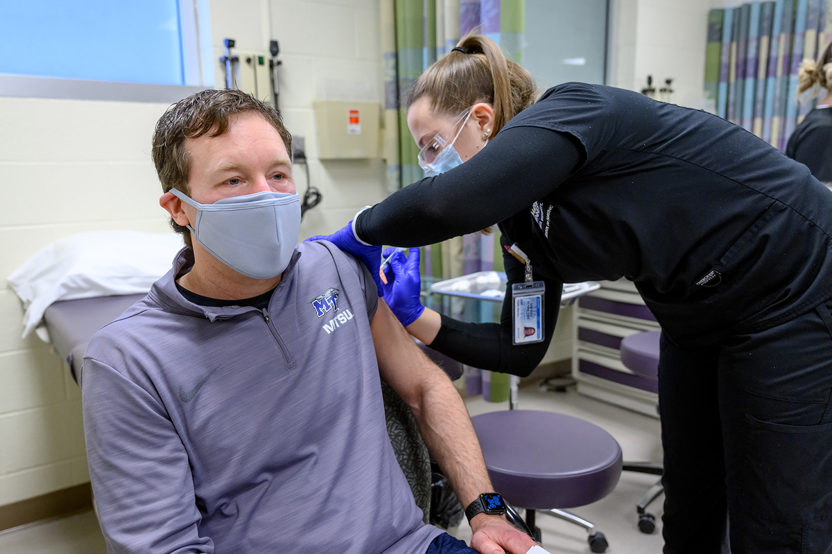 Bob Batcheller, who will be a volunteer at the MTSU School of Nursing’s Cason-Kennedy Nursing Building Moderna COVID-19 vaccines, receives his first dose from nursing student Taylor Shanklin Thursday, Feb. 25. Batcheller is co-owner of Textbook Brokers on Greenland Drive. He will receive his second dose in three weeks. (MTSU photo by J. Intintoli)