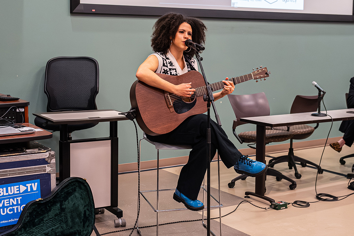 Country music artist Julie Williams performs a song as part of the launch of her collaborative multicity college tour titled “Green Room Conversations” with a panel discussion March 27 in the College of Education Building at Middle Tennessee State University in Murfreesboro, Tenn. The tour’s purpose is to raise awareness about sexual harassment in the music industry. Also pictured is MTSU College of Media and Entertainment Dean Beverly Keel, right, and fellow panelist Maggie Arthur, director of Calling All Crows. (Photo courtesy of The Change Agent·cy)