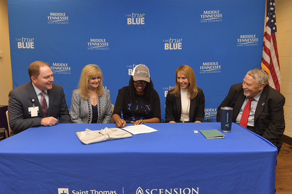 MTSU student veteran Martinna Young, center, signed an agreement making her the inaugural member of the Ascension Saint Thomas Nursing Corps, a partnership with MTSU that seeks to create a robust pipeline of strong registered nurse candidates who are also military veterans. Ascension Saint Thomas CEO and President Tim Adams, left, MTSU School of Nursing Director Jenny Sauls, Ascension Saint Thomas COO Michelle Robertson and MTSU College of Behavioral and Health Sciences Dean Terry Whiteside viewed the signing Tuesday, Nov. 26, in the Daniels Veterans Center on the MTSU campus. (MTSU photo by James Cessna)