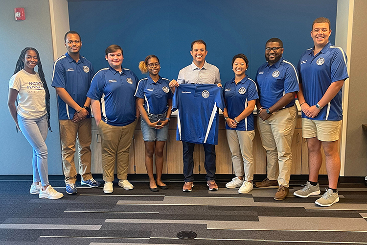 Murfreesboro Mayor Shane McFarland, center, an MTSU alumnus and former student government president, poses with the MTSU Student Government Association Executive Board after receiving an SGA polo shirt with his name on it. McFarland spoke at the Center for Student Involvement and Leadership retreat Wednesday, Aug. 3, at Murfreesboro Police Department headquarters.