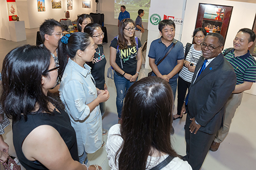 MTSU President Sidney A. McPhee discusses the photographs on display in the Todd Art Gallery with attendees of a Sept. 11 reception and auction there. The photos, which McPhee took while on trips to China during his presidential tenure, will be on display at the Rutherford County Chamber of Commerce Sept. 22-Oct. 22. (MTSU photo by J. Intintoli)
