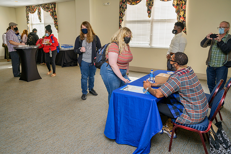 Pulitzer Prize-winning author Mitchell Jackson, seated right, chats with a student during the book signing and reception for Jackson following his talk Oct. 6, 2021, in the James Union Building as part of the Pulitzer Prize Lecture Series sponsored by the John Seigenthaler Chair of Excellence in First Amendment Studies, the College of Media and Entertainment and the Free Speech Center at MTSU. Also capturing the moment at right is journalism professor Leon Alligood. (MTSU photo by Andy Heidt)
