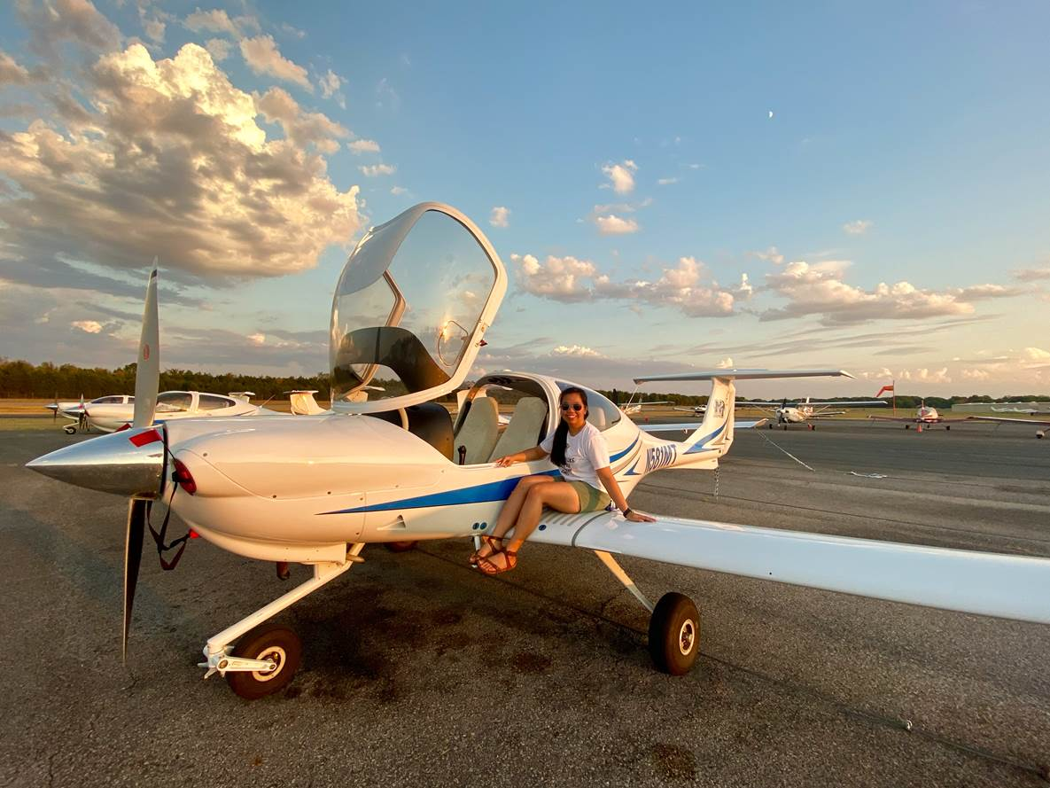 Nakanya Rodruepid, an MTSU senior from Chiang Mai, Thailand, who’s majoring in aerospace, sits on the wing of a small airplane. Roduepid is an MTSU international student ambassador, one of several students from other countries who volunteer to help new international students become adjusted to their new surroundings. (Photo submitted)
