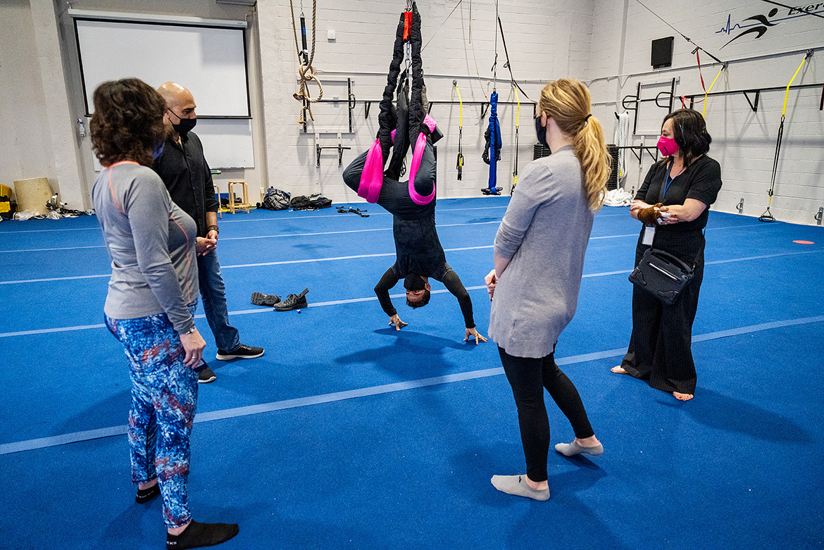 Framauro Fortich-Perez hangs upside down while demonstrating the PENDL, a device he created to help improve physical flexibility and alleviate back pain. Observing during a March 26 demonstration in Alumni Memorial Gym are, from left, University Studies lecturer Debra Haber, graduate research assistant Rawsam Alasmar, PENDL Co-Founder and Director of Operations Brenna Rozario, and PENDL Business-to-Business Coordinator Patricia Lefler. The Exercise Science Program has conducted evidence-based research into the PENDL. (MTSU photo by Andy Heidt)