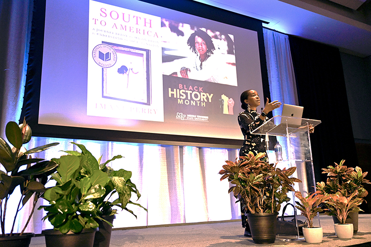 National Book Award-winning scholar Imani Perry makes a point while discussing how the South's people and cultures have influenced the nation during her Feb. 9 public lecture at Middle Tennessee State University. Perry, the Hughes-Rogers Professor of African American Studies at Princeton University and an interdisciplinary scholar of race, law, literature and African American culture, is the author of “South to America: A Journey Below the Mason-Dixon to Understand the Soul of a Nation," the cover of which is displayed on the screen behind her. Her talk was a part of MTSU's observance of Black History Month. (MTSU photo by J. Intintoli)