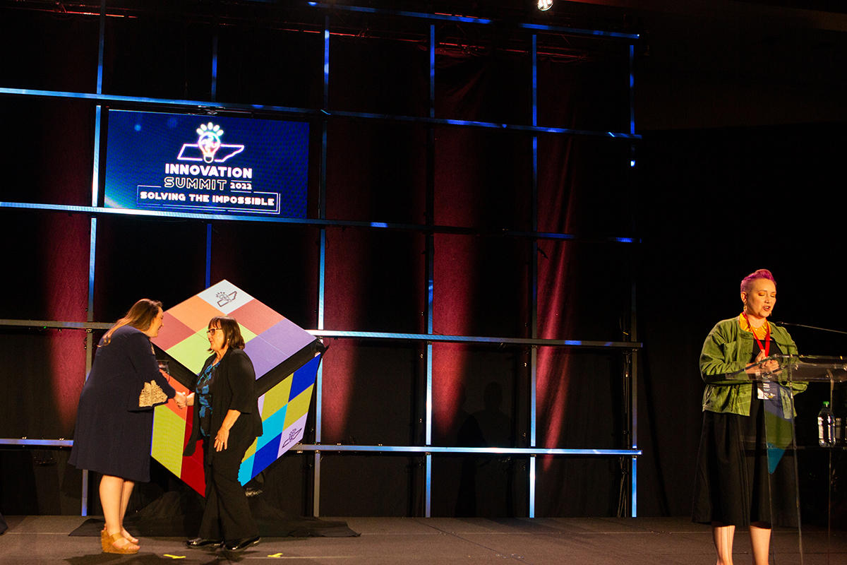 Kristin McQueen, left, a relationship manager with the Tennessee STEM Innovation Network, presents MTSU’s Judith Iriarte-Gross with the 2022 TSIN Excellence in Advocacy Award Tuesday, May 10, at the Music City Center in Nashville, Tenn., as Misty Brown, far right, TSIN STEM relationship manager, announces the various awards. Iriarte-Gross and the MTSU WISTEM Center received the award for all they do for underrepresented groups in STEM education. (Tennessee STEM Innovation Network photo by Tina Gionis)