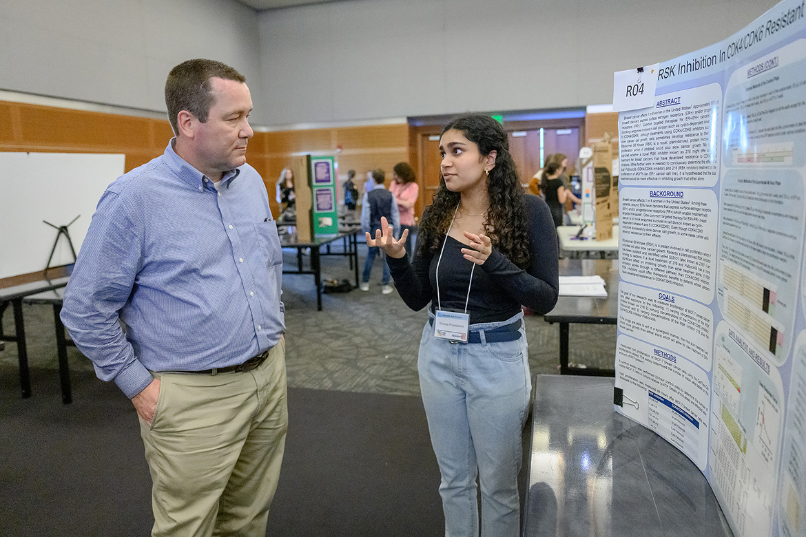 Kevin Ragland, left, Middle Tennessee State University associate professor, event coordinator and MTSU Tennessee STEM Education Center associate director, learns about the complex, eight-month breast cancer research that Streya Priyadarshi, 17, a junior at Harpeth Hall in Nashville, Tennessee, performed, much of it through a Vanderbilt University lab. The annual Middle Tennessee STEM Innovation Hub Expo took place in the MTSU Student Union Ballroom Wednesday, April 5. (MTSU photo by J. Intintoli)