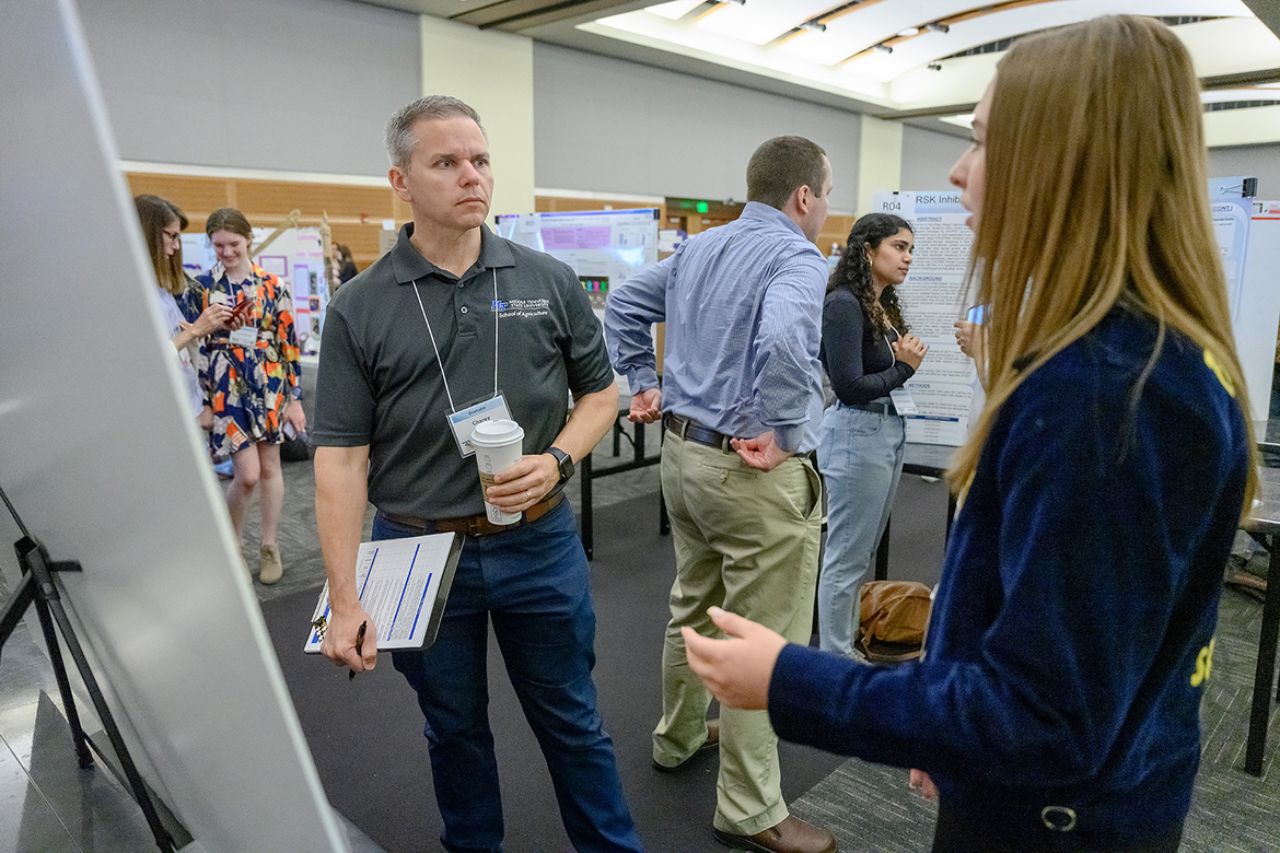 Chaney Mosley, left, Middle Tennessee State University School of Agriculture assistant professor and MTSU Tennessee STEM Education Center associate director, listens as FFA member and Stewarts Creek High School freshman Catherine Denton discusses her agriculture-related research Wednesday, April 5, in the MTSU Student Center Ballroom. (MTSU photo by J. Intintoli)
