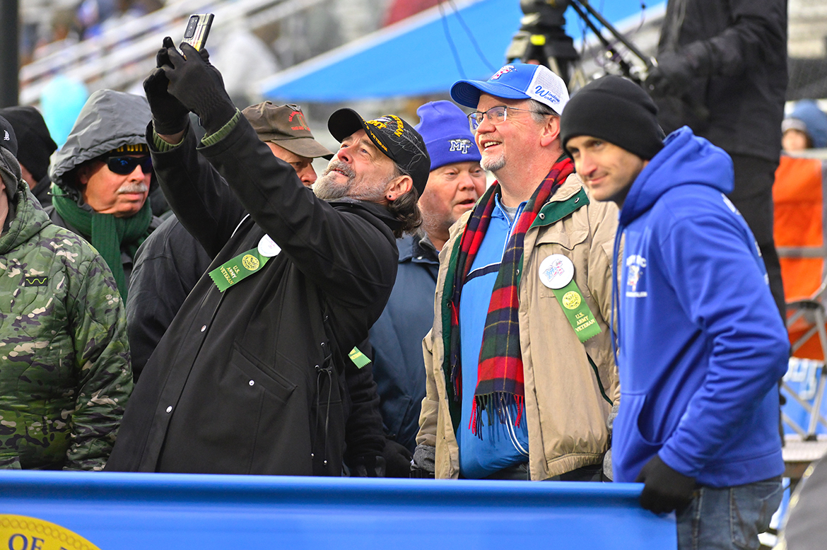 A U.S. Army veteran takes a selfie of himself and his Army veterans with his cell phone in Floyd Stadium in November 2022, as part of Salute to Veterans and Armed Forces game activities. Veterans, active-duty military and their families are invited to attend the 41st annual ‘Salute game’ Saturday, Nov. 11, on the MTSU campus. (MTSU file photo by Cat Curtis Murphy)