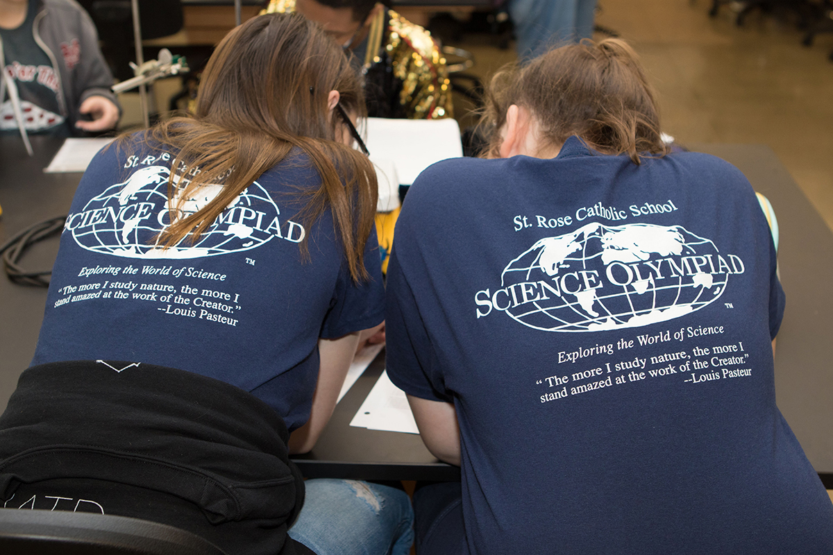 Hanna Fletcher and Kenley Baltz, eighth-graders at St. Rose of Lima Catholic School sport matching T-shirts as they work to record data for their water quality project during the 24th Regional Science Olympiad in the MTSU Science Building. (MTSU photo by James Cessna)