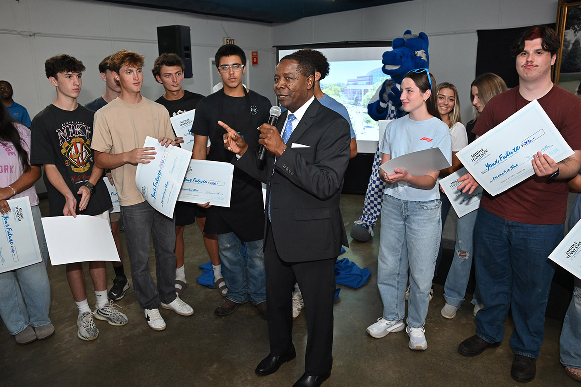 Middle Tennessee State University President Sidney A. McPhee, center, talks with students at the 2025 True Blue Tour kickoff reception held Tuesday night, Sept. 16, at the Blue Ribbon Circle Club in Shelbyville, Tenn., after he doled out $250 book scholarships to 22 of them. “The most important thing is for you to get a degree. And MTSU is here to make sure you’re successful,” McPhee tells them. (MTSU photo by James Cessna)