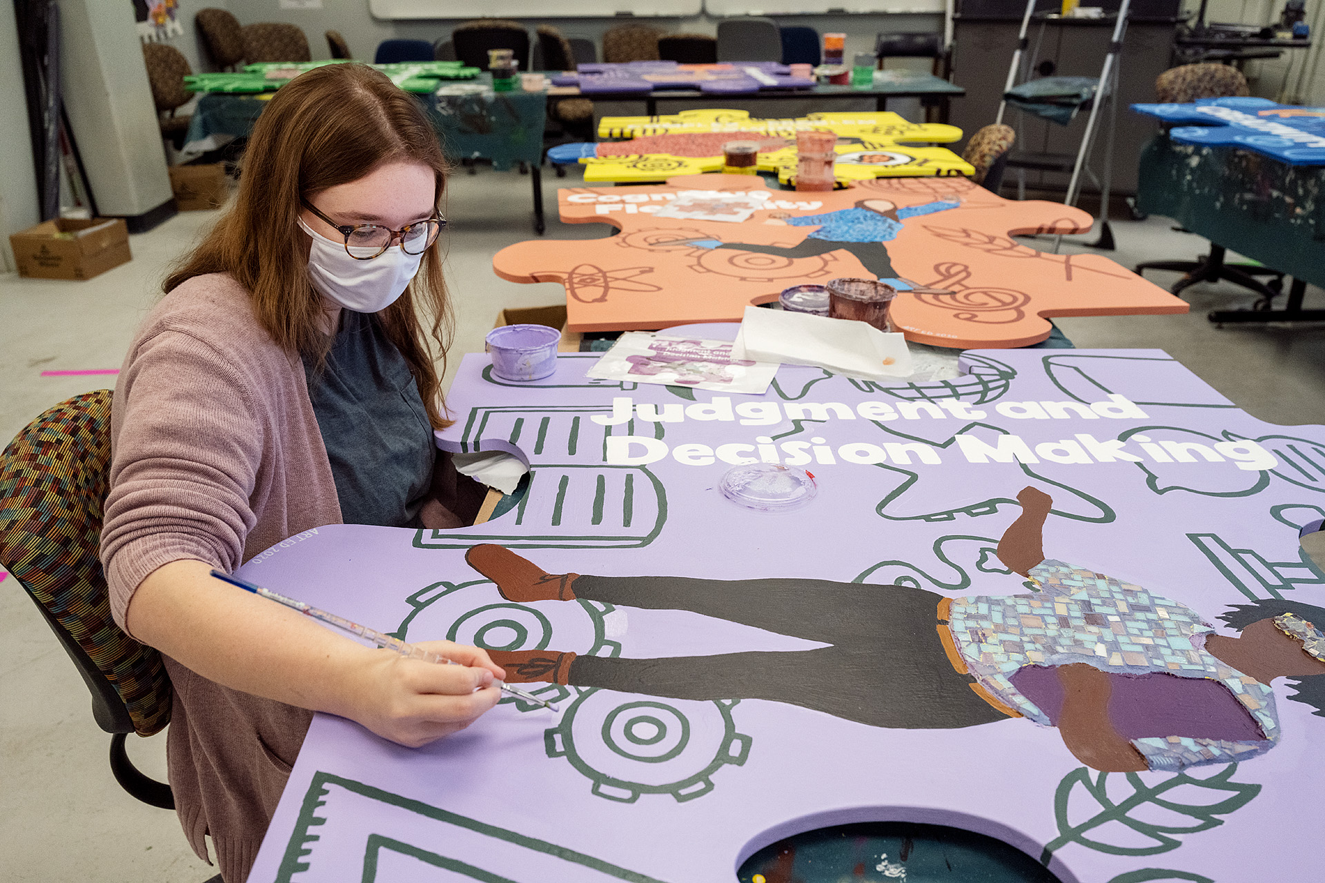 MTSU senior Menley Saylor, an art education major from Shelbyville, Tenn, touches up the paint on an oversized wooden puzzle piece for "judgment and decision-making" in Todd Hall Thursday, Nov. 19. The 10 different handcrafted puzzle pieces, now with mosaics added and ready for display, are part of a public art project collaboration between the College of Liberal Arts and the College of Basic and Applied Sciences to show students the interdisciplinary core skills they need for success. (MTSU photo by Andy Heidt)
