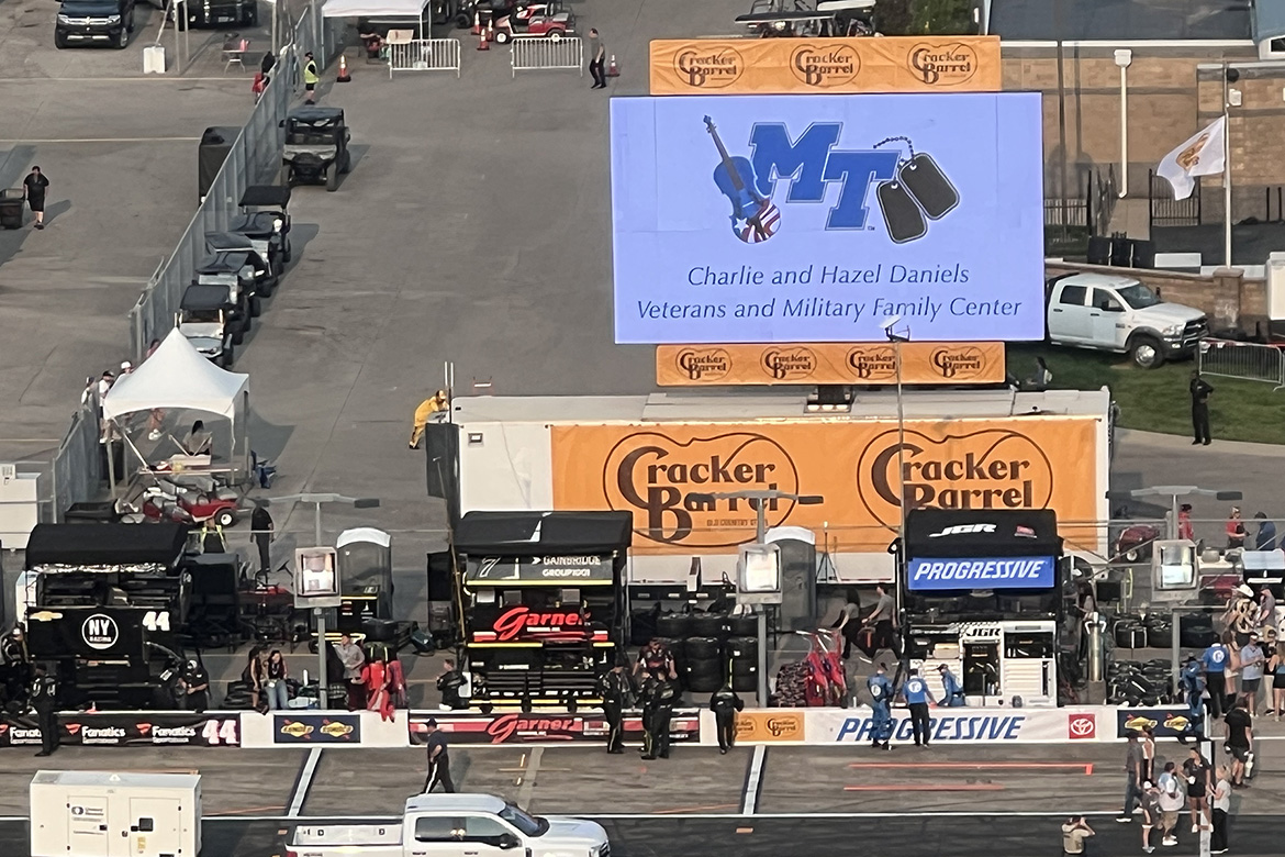 A large sign promoting the Charlie and Hazel Daniels Veterans and Military Family Center at Middle Tennessee State University is positioned along pit row for the 2025 NASCAR racing weekend May 30-June 1 at Nashville Superspeedway in Lebanon, Tenn. (MTSU photo by Andrew Oppmann)