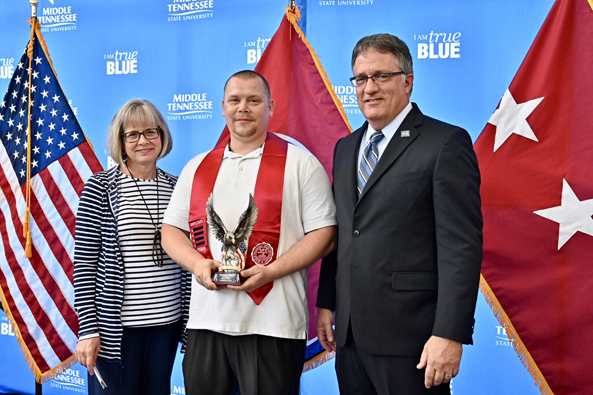 MTSU graduating student veteran Derrick Jones, second from left, accepts the Veteran Leadership Award from Deb Sells, left, vice president of Student Affairs, and Provost Mark Byrnes Wednesday, April 24, during the Graduating Veterans Stole Ceremony at the Miller Education Center. Jones has been a student worker in the Daniels Veterans Center.