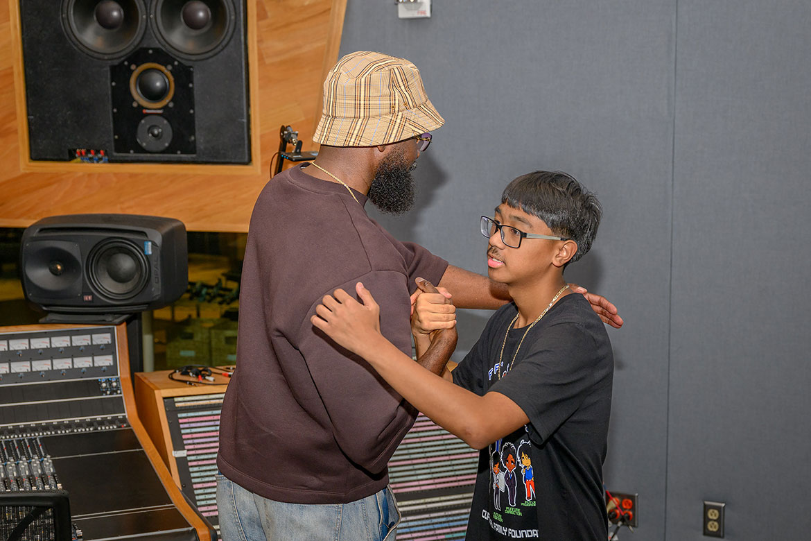 Middle Tennessee State University alumnus and adjunct recording industry professor Torrance "Street Symphony" Esmond exchanges a hug and handshake with one of the 10 participants of the Cliff’s Crew who visited campus July 30, 2025, to hear about Esmond’s experiences in the music industry and to tour a studio inside the College of Media and Entertainment Building on campus in Murfreesboro, Tenn. (MTSU photo by James Cessna)