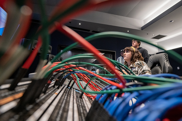 Dani Gillis, center, of Gibsonia, Pa., a junior audio production major in MTSU's Department of Recording Industry, listens closely to a snippet of a "Studio Saturdays" recording session with members of the School of Music's Commercial Music Ensemble at the mixing console in Studio D in the brand-new Main Street Studios facility. Standing behind her are Samuel Roth, left, a senior audio production major from Farmington Hills, Mich., and Tanner Alguire, a junior audio production major from Cleveland, Tenn. (MTSU photo by Cat Curtis Murphy)
