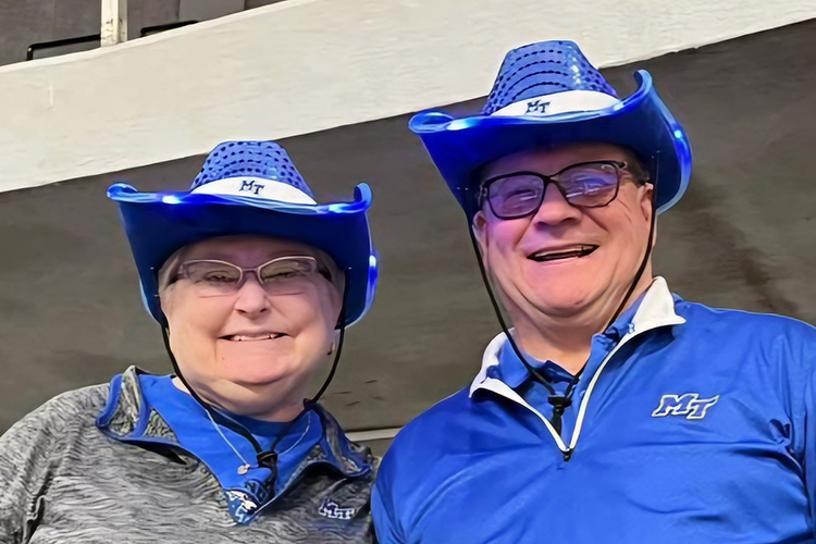 In this 2024 photo, Middle Tennessee State University spring 2025 graduate Sue Stephens, left, and husband Tim don their Blue Raider gear in support of the women's basketball team at the Von Braun Center in Huntsville, Ala. Sue Stephens, soon to be 63, will receive her degree in integrated studies during the Saturday, May 10, morning ceremony at Murphy Center in Murfreesboro, Tenn. (Submitted photo)