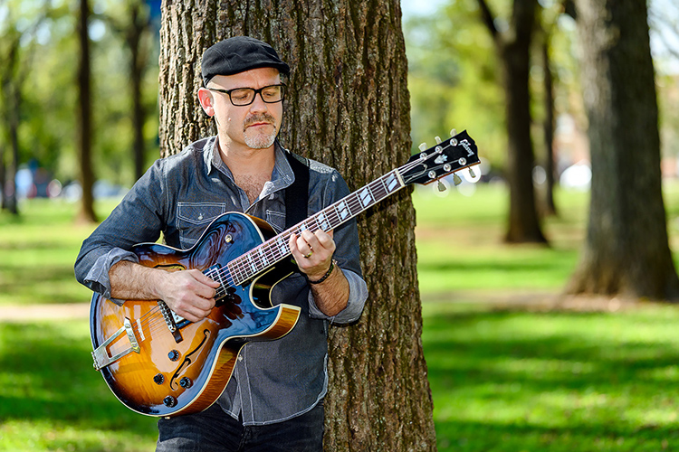 Professional guitarist and student Beau Tackett, a student in the Master of Music program, picks his guitar in Walnut Grove. (MTSU photo by J. Intintoli)