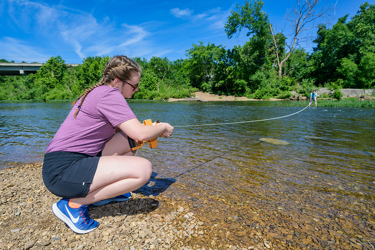 Rising senior Jacqueline Williams, left, of Drummonds, Tenn., holds one end of the tape and research assistant professor Cole Easson the other as they measure a portion of the Stones River recently. In a Stones River Watershed research project, they will collect DNA samples from 10 locations across the area. The Stones River Watershed Association and a campus committee chose the Easson-Williams proposal for a $6,500 stipend. (MTSU photo by Andy Heidt)