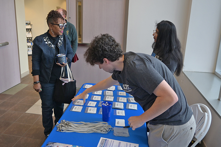 Attendee Angela Bingham, left, of Murfreesboro Rescue Mission, checks in at the registration table for the 2025 Tech Vision Conference held April 10-11 in the Miller Education Center atrium on Bell Street on the MTSU campus in Murfreesboro, Tenn. (MTSU photo by Jimmy Hart)