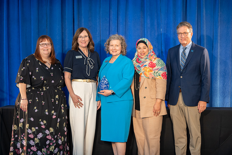 Middle Tennessee State University associate management professor Kristie Abston, center, holds the outstanding leadership and community engagement award she received for her work co-organizing the 2025 Tech Vision Conference held April 10-11 in the Miller Education Center atrium on Bell Street on the MTSU campus in Murfreesboro, Tenn. Pictured, from left, are Vice Provost Amy Aldridge-Sanford, Management Chair Deana Raffo, Abston, Information and Analytics associate professor Sam Zaza, and University Provost Mark Byrnes, whose office co-sponsored the event. (MTSU photo by James Cessna)